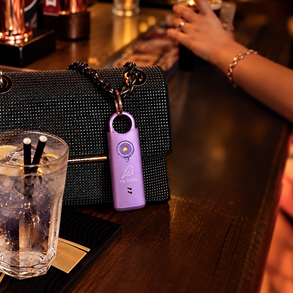 My Robin personal safety alarm attached to a handbag in a restaurant setting